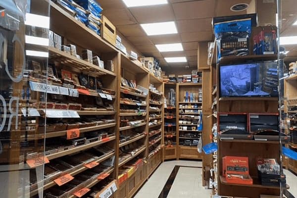 Inside the walk-in humidor at Smokey News, cedar shelves of premium cigar boxes.