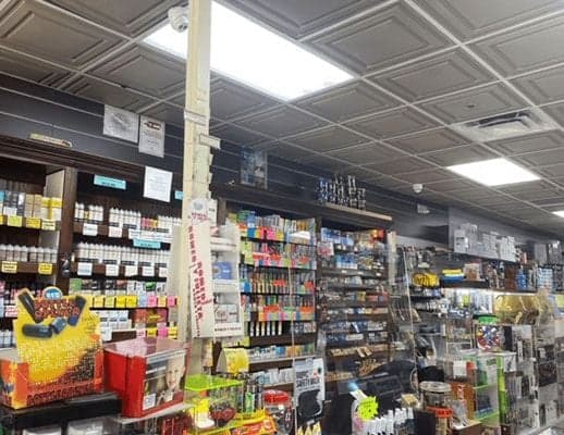 The main aisle at Smokey News, shelves stocked floor to ceiling.